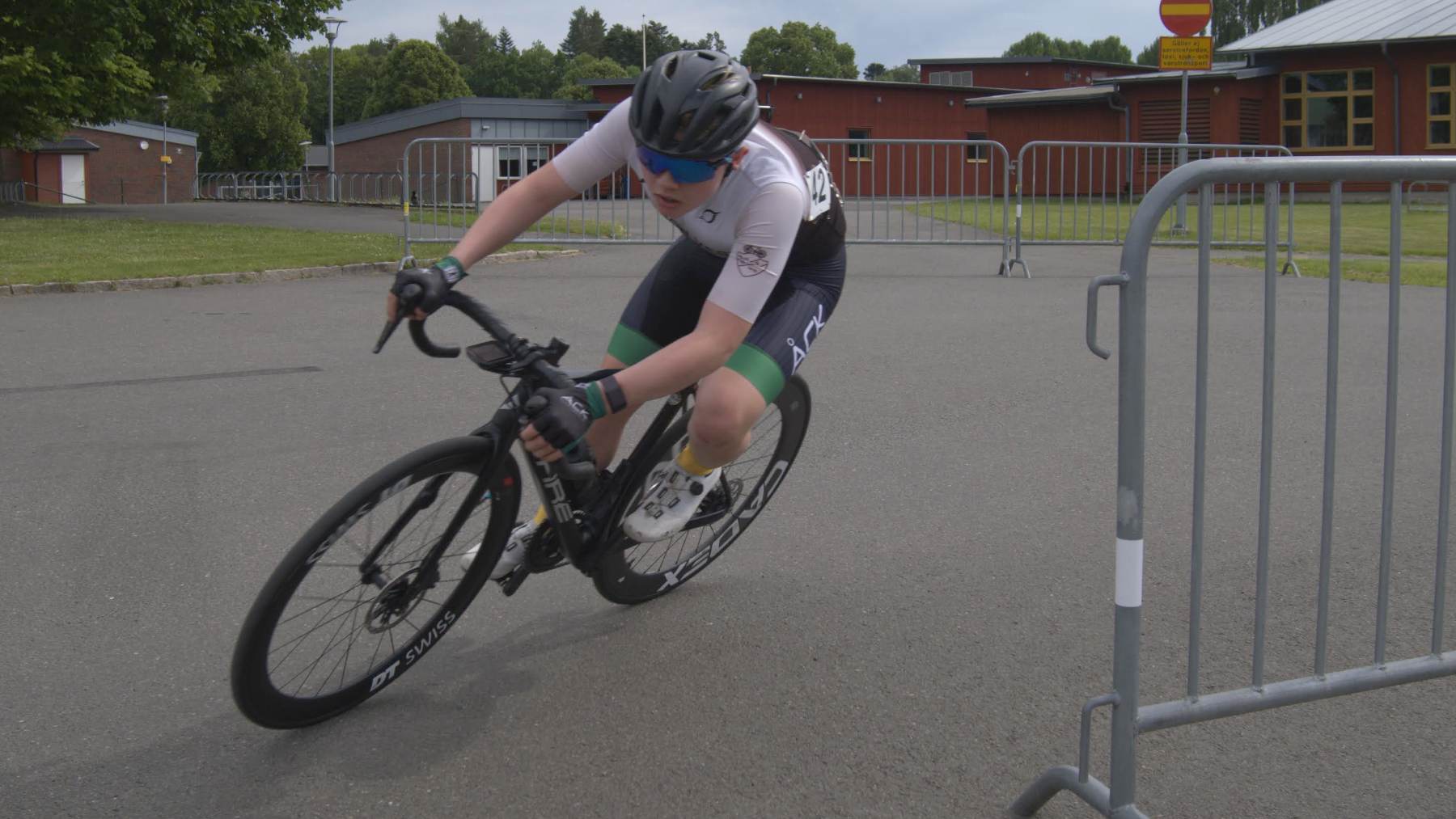 A road cyclist leans hard through a tight corner on a closed course.